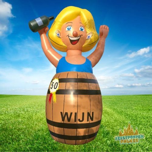 Grote opblaasfiguur van een naakte vrouw in een wijnvat, met ondeugende uitstraling en feestelijke details, ideaal voor een ludieke 50e verjaardag.